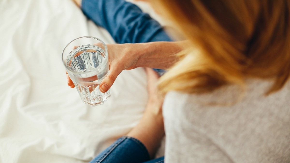 Photo of a woman holding a glass of water