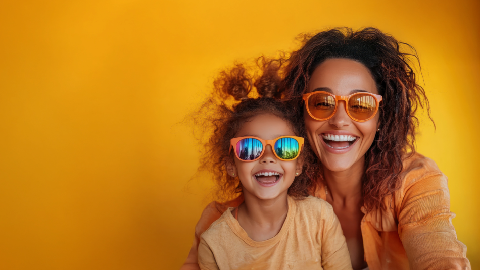 A woman and girl smiling together while wearing sunglasses