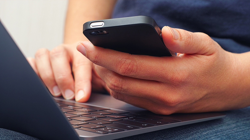 Customer on their phone and laptop